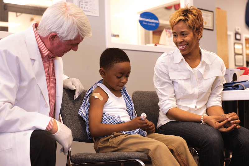 Pharmacist giving child a shot